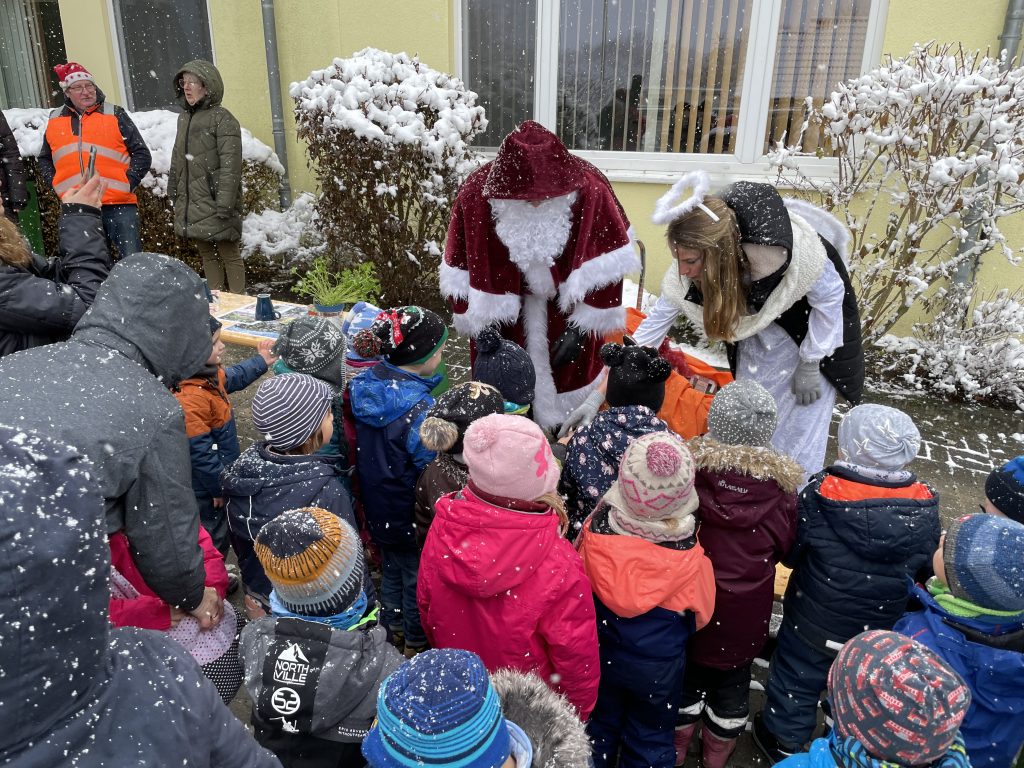 Weihnachtsmann verteilt Geschenke an Kinder