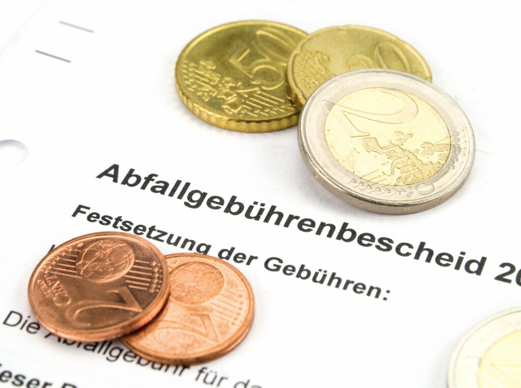 Euromünzen liegen auf einen Abfallgebührenbescheid