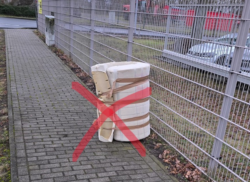 illegal abgelegte Matratze vor dem Zaun des Wertstoffhofes.