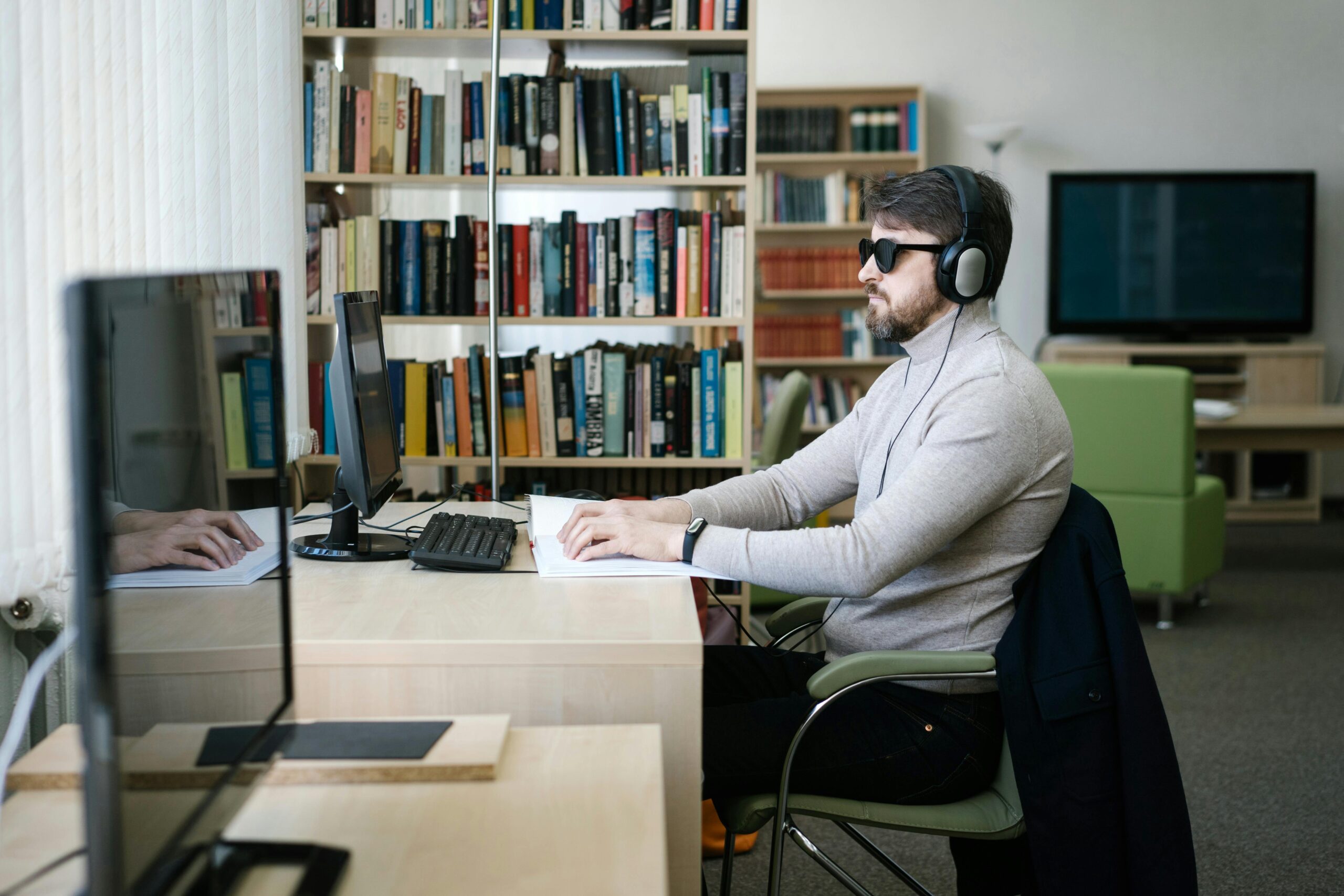 Blinder Mann sitzt vor der Computer