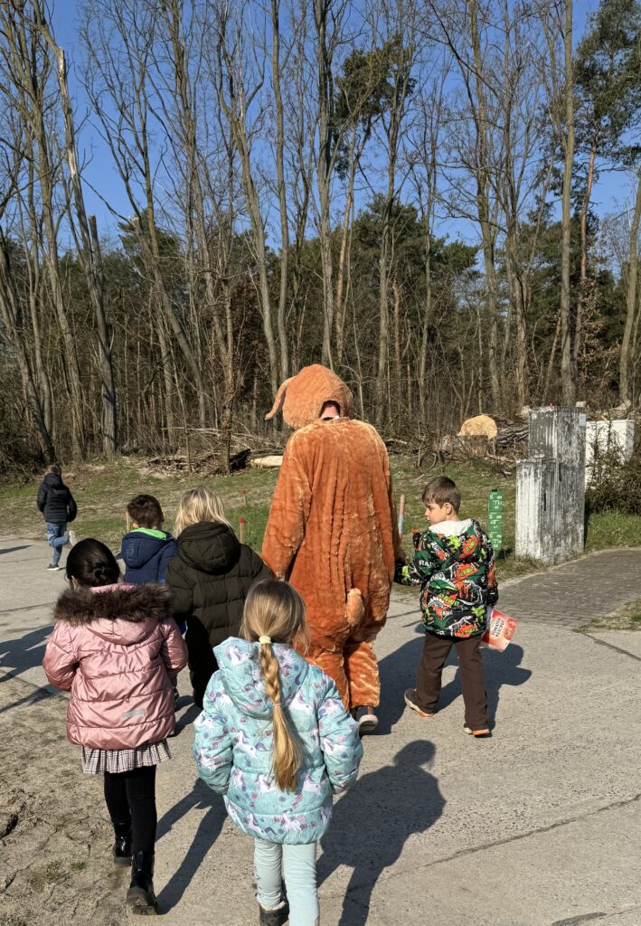 Kinder laufen gemeinsam mit dem Osterhasen.