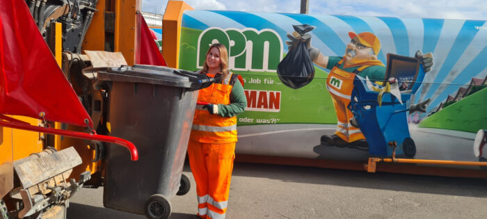Eine Frau steht vor einem Container.
