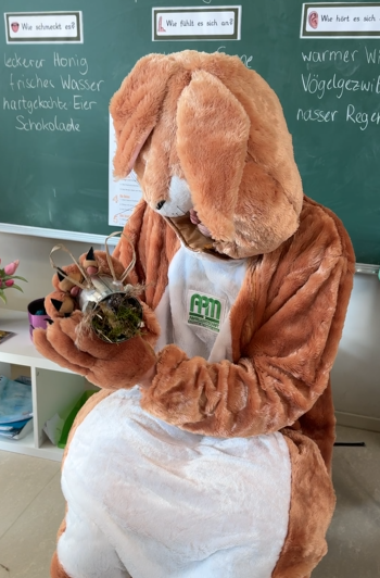 Osterhase hält Insektenhotel.